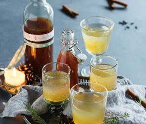 Apfel-Punsch-Sirup in einer Flasche und vier Gläsern