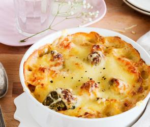 Bunter Gemüseauflauf in einer Auflauform auf einem Tisch.