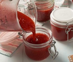 Gläschen, die mit Erdbeer-Rhabarber-Konfitüre befüllt werden