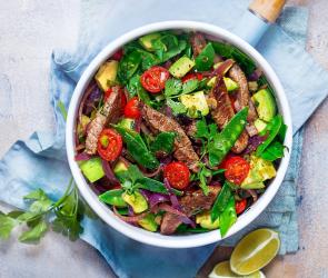 Gebratene Rinderfiletstreifen mit Tomaten und Zuckerschoten in einem tiefen Teller angerichtet.