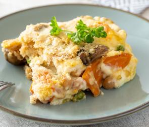 Ein Stück Gemüseauflauf mit Pilzen auf einem Teller.