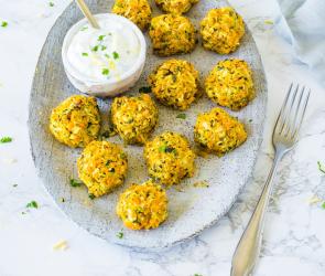 Elf Gemüsebällchen auf Teller mit Joghurt-Dip.