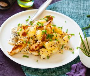 Gnocchi mit Putenstreifen auf weißem Teller.