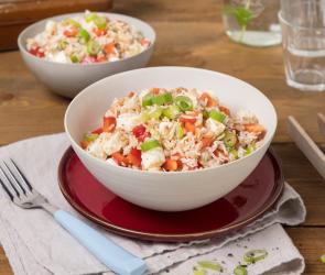 Zwei Teller mit griechischem Dinkel-Reis-Salat auf gedecktem Tisch.