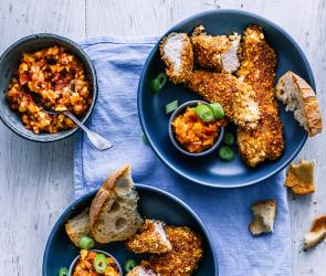 Knusper Hähnchen mit Mango-Salsa in zwei Tellern.