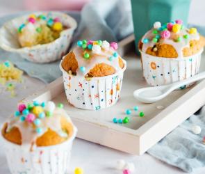 Vier Konfetti-Muffins mit bunten Streuseln