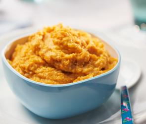 Kürbis-Risotto mit Kalbfleisch in einer Schale angerichtet.