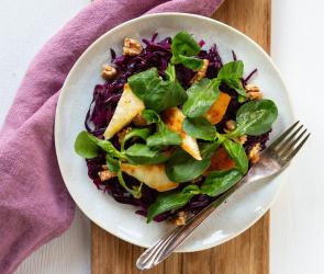 Lauwarmer Rotkohlsalat mit gebratenem Halloumi und Walnüssen in einer Schale angerichtet
