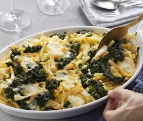 Nudelauflauf mit Spinat wird aus einer Auflaufform genommen.