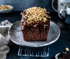 Nussiger Schokoladenkuchen auf einer Kuchenplatte.