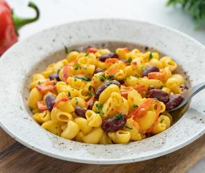 Pasta mit Bohnen, roter Paprika und Nacho-Käsesauce in einem Teller.