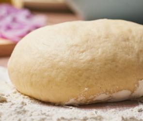 Pizzateig auf einer bemehlten Arbeitsfläche.