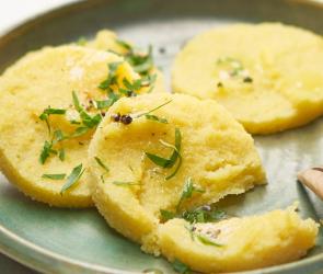 Polenta als Taler mit Petersilie auf einem Teller.