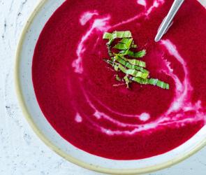 Rote-Bete-Kokos-Suppe mit Limette in einer Schale mit Löffel.