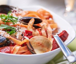 Rote Bete Tagliatelle mit Meeresfrüchten auf einem Teller angerichtet.