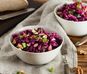Zwei Schalen mit Rotkohlsalat auf Holztisch.
