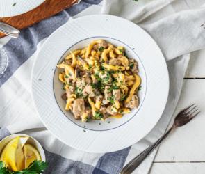 Schweinegeschnetzeltes mit Spätzle in Rahmsoße auf einem Teller angerichtet.