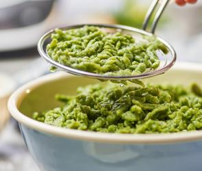 Spätzle grün werden mit einer Schaumkelle in eine Schüssel gegeben.
