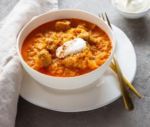 Szegediner Gulasch mit Creme fraîche garniert in Schüssel