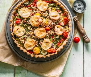 Vollkorn-Gemüse-Quiche mit Ziegenkäse auf einem Tisch.