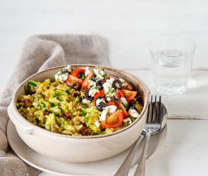 Zucchini-Bulgur mit Feta und Tomaten in Schüssel mit Besteck