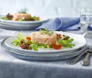 Räucherlachs-Tatar auf Avocado auf Teller.