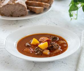Ungarisches Gulasch mit Brot an der Seite.