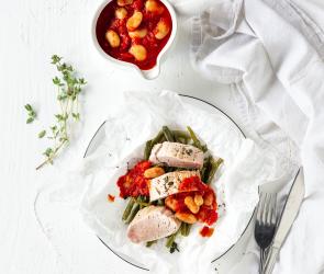 Schweinefiletmit Tomatensauce auf einem Teller.