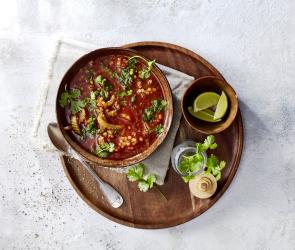 Vegane Linsen-Tomaten-Suppe in eine Schüssel.
