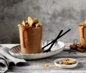 Mousse au Chocolat in zwei Gläsern mit Spekulatiusbröseln garniert.