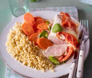 Zartweizen, Möhren und Schweinefleisch auf einem Teller.