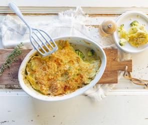Kartoffelgratin in einer Auflaufform mit Brokkoli.