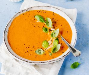 Teller mit Suppe und Basilikum