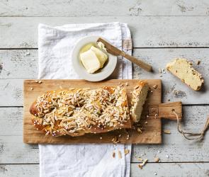 Hefezopf auf Brett mit Schale mit Butter.