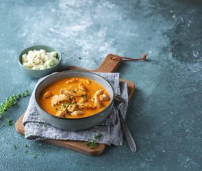 Schale Blumenkohlreis und Schale mit Putengulasch in roter Sauce