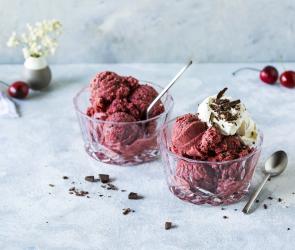 Schwarzwälder-Kirsch-Eis zu Kugeln portioniert serviert in zwei Glasschälchen.