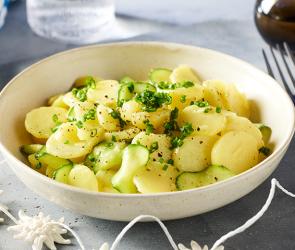 Bayrischer Kartoffel-Gurkensalat mit Schnittlauch in einer großen Schüssel.