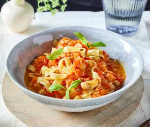 Turbo-Tagliatelle mit Paprika-Sugo mit Basilikum verziert in einer Schüssel.