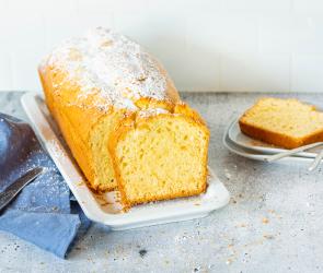 Angeschnittener Eierlikörkuchen aus der Kastenform mit Puderzucker.