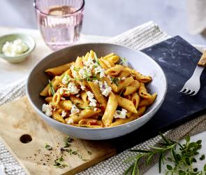 One-Pot Pasta mit Gemüsepesto mit einem Glas Wasser.