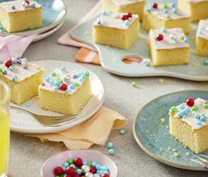 Veganer Fantakuchen vom Blech mit bunten Perlen in Stücke geschnitten.