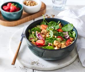 Erdbeer-Spinatsalat mit Hähnchen in einer Schüssel angerichtet.