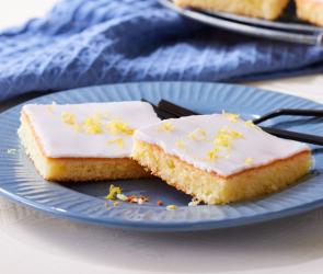 Zitronenkuchen vom Blech in Stücke geschnitten.