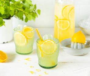 Zitronenlimonade mit Zitronenscheiben und Strohhalm in Gläsern.