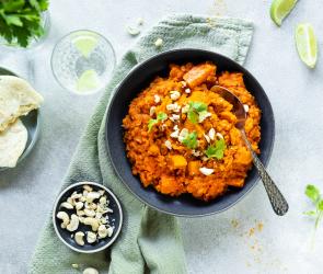 Linsen Dal mit Kürbis in einer dunklen Schüssel.