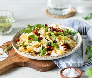 Mediterraner Nudelsalat auf einem Teller mit Kräuterdressing