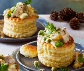 Hübsch dekorierte Pasteten auf dunlen Tellern auf einem festlichen Tisch.