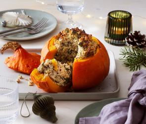 Hokkaido Kürbis gefüllt mit Maronen, Nüssen und Reis, angeschnitten.