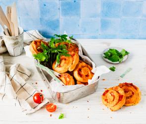 Mehrere Pizzaschnecken aus Quark-Öl-Teig in einer Schale.