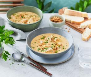 Pute in Senfsauve in zwei Schüsseln mit Kräutern dekoriert.